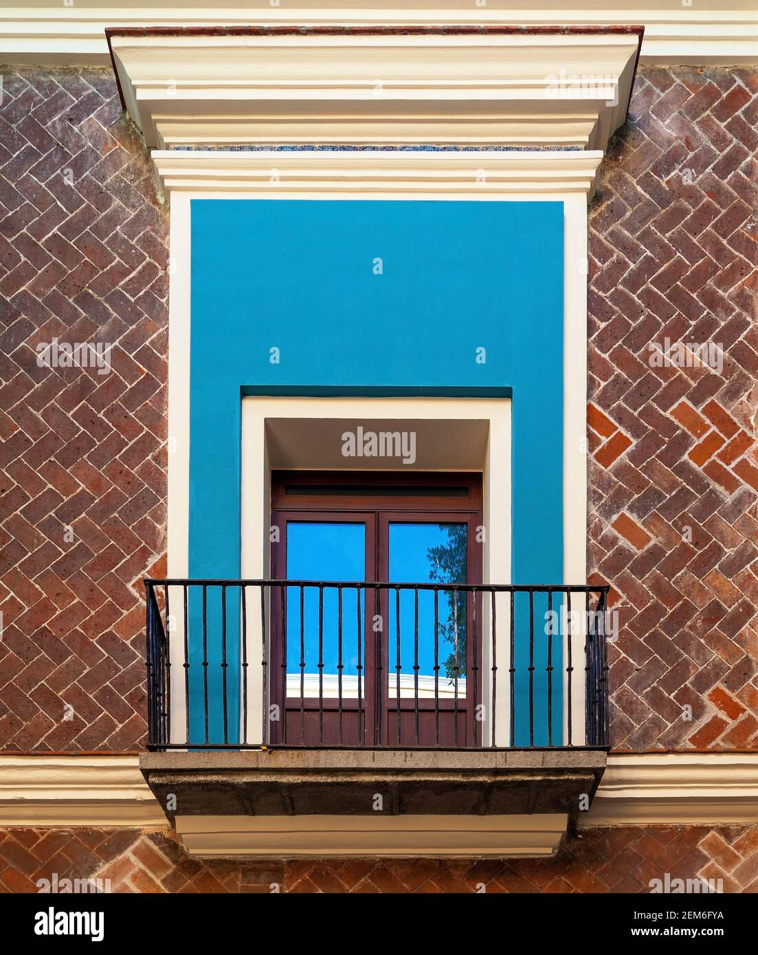 Ventana de balcón con fachada de ladrillo, Puebla, México. Foto de stock