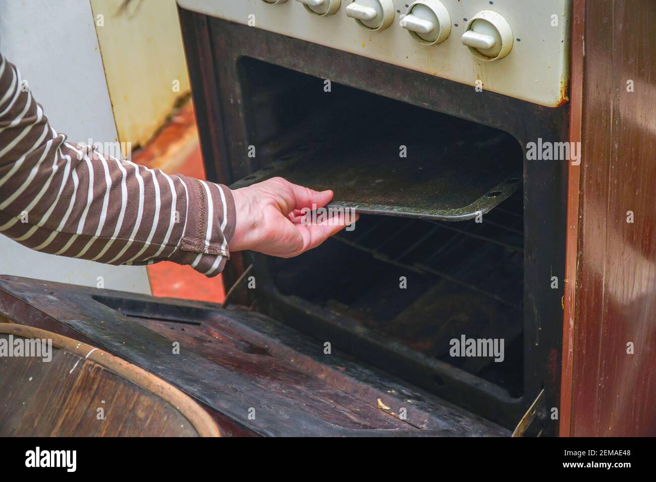 Una mujer saca una hoja de horno del horno de una vieja estufa de gas  Fotografía de stock - Alamy