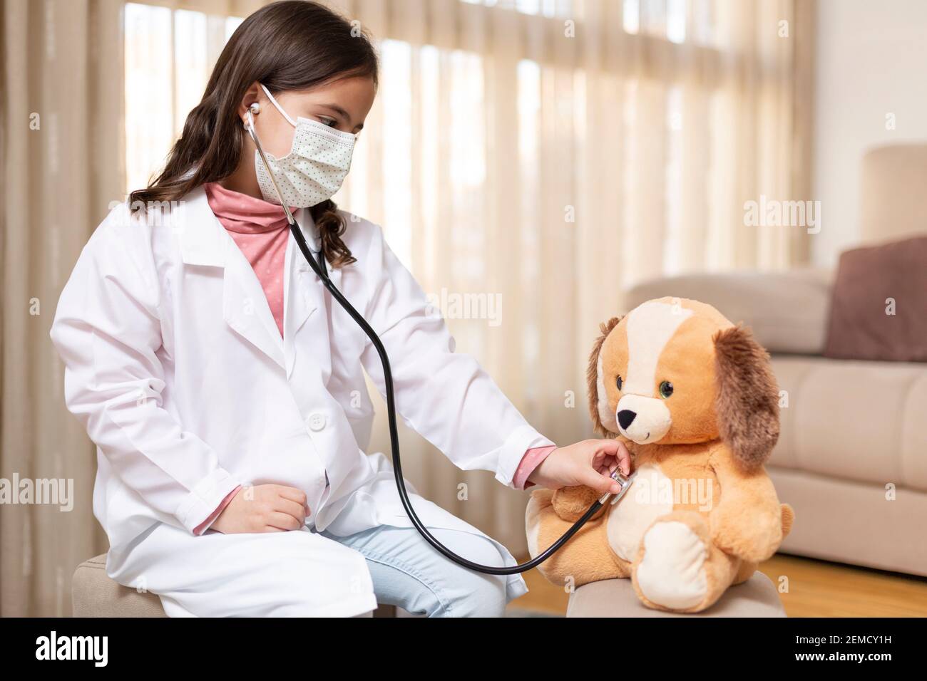 Niño pequeño vestido como un médico que examina un oso de peluche con un  estetoscopio. Concepto de salud y bienestar en el hogar. Espacio para texto  Fotografía de stock - Alamy