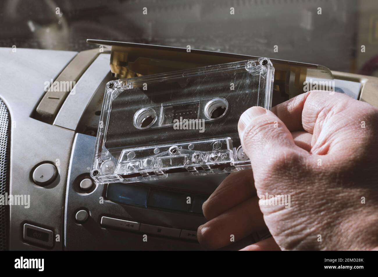 La cinta de audio se inserta en una grabadora de cintas estéreo con los símbolos ampliamente utilizados sin marca comercial Foto de stock