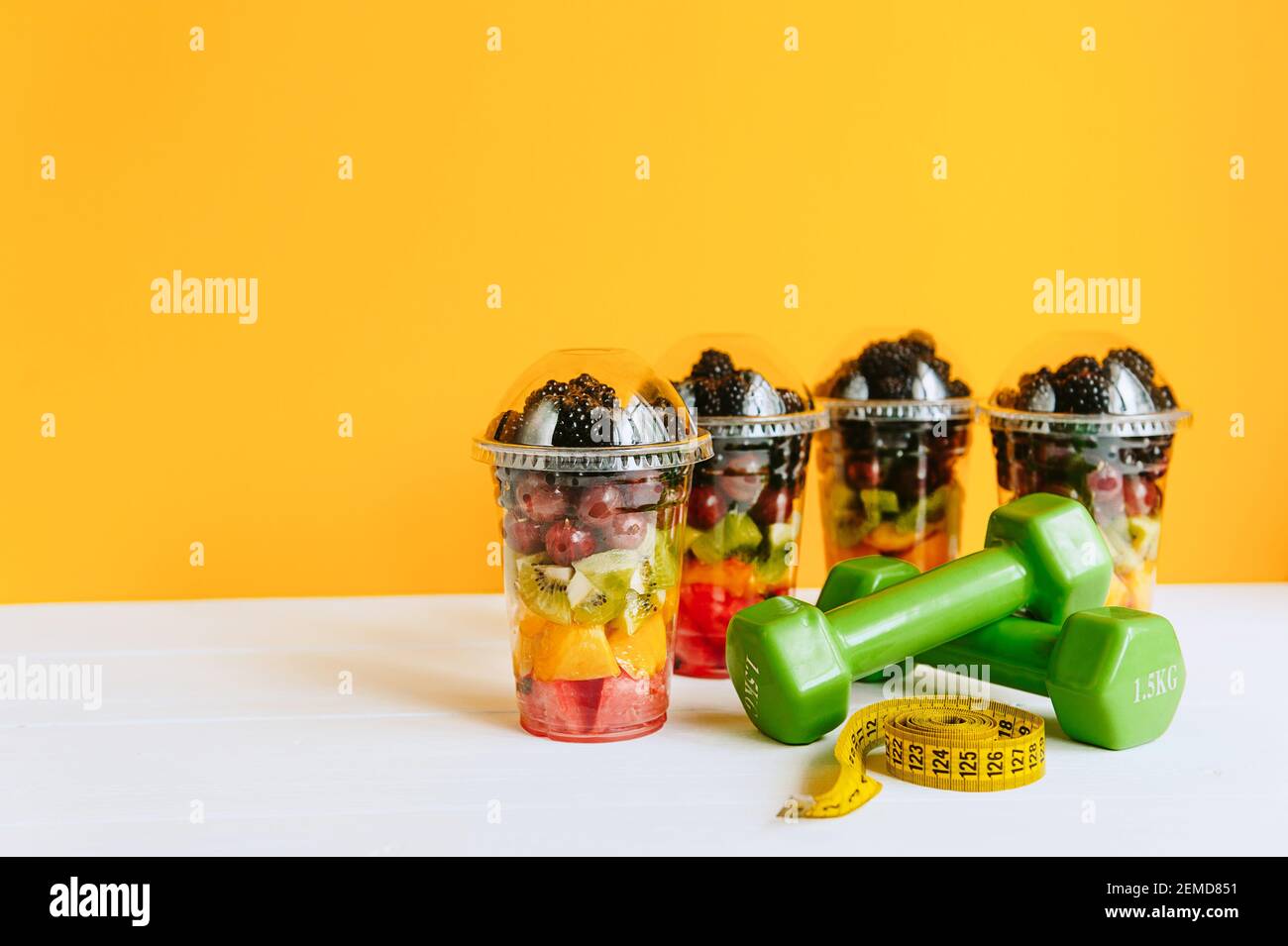 Fruta en un vaso, una campana y una cinta para medir el cuerpo