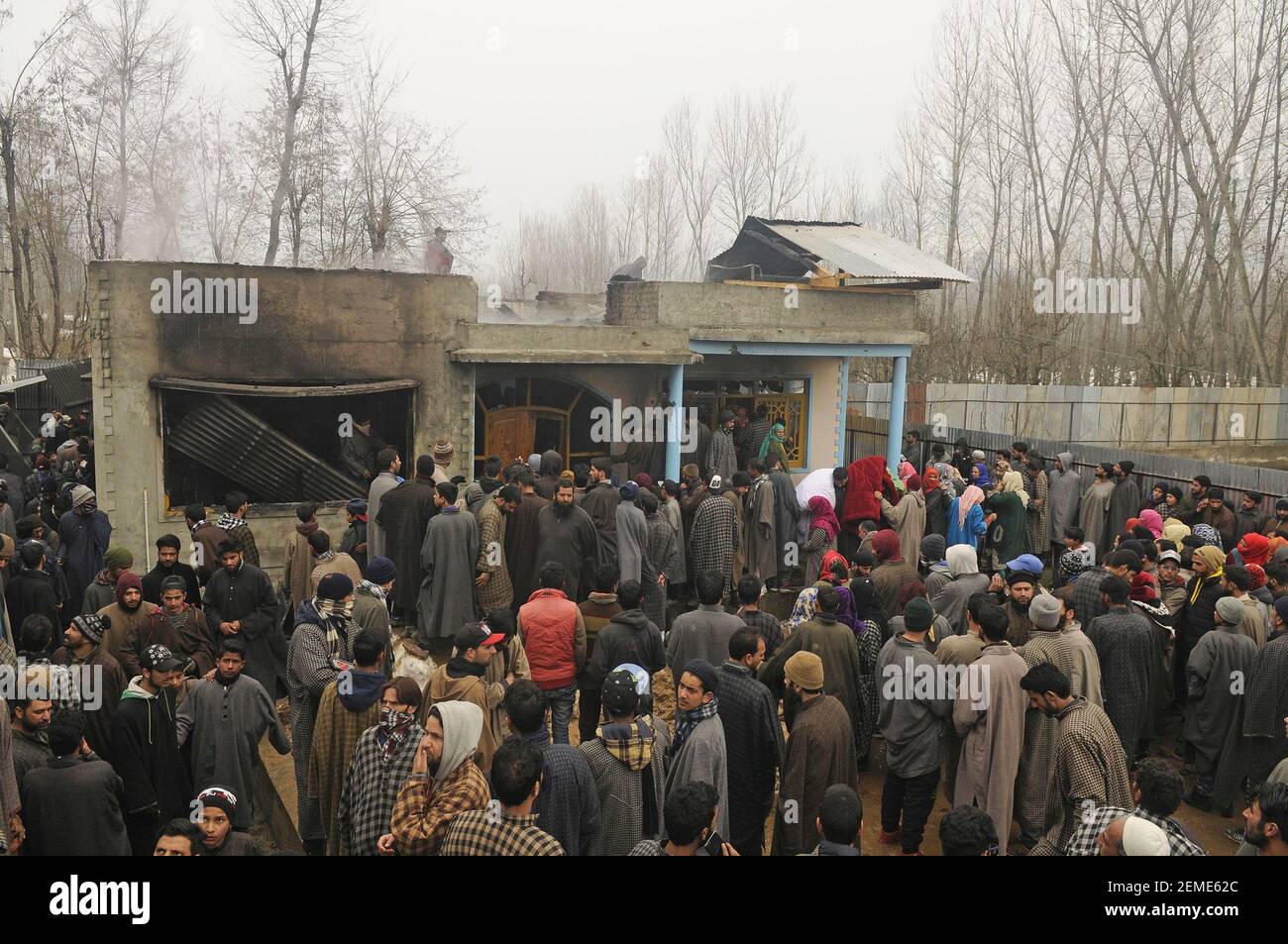 SRINAGAR, INDIA – FEBRERO de 12: La gente se reúne cerca de una casa que fue dañada durante una pelea de armas entre militantes y fuerzas de seguridad en la zona de Ratnipora, en el distrito Pulwama del sur de Cachemira, a unos 30 kilómetros al sur de Srinagar, el 12 de febrero de 2019 en Jammu y Cachemira, India. (Foto de Waseem Andrabi/ Hindustan Times/Sipa USA) Foto de stock