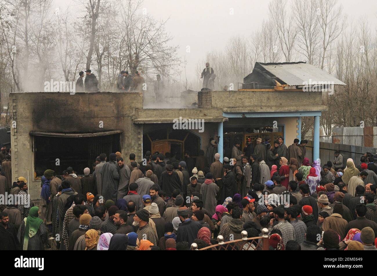 SRINAGAR, INDIA – FEBRERO de 12: La gente se reúne cerca de una casa que fue dañada durante una pelea de armas entre militantes y fuerzas de seguridad en la zona de Ratnipora, en el distrito Pulwama del sur de Cachemira, a unos 30 kilómetros al sur de Srinagar, el 12 de febrero de 2019 en Jammu y Cachemira, India. (Foto de Waseem Andrabi/ Hindustan Times/Sipa USA) Foto de stock