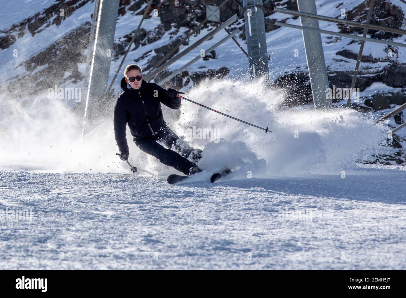 Val Thorens, Francia - 20 de febrero de 2020: Feliz joven disfrutando de las vacaciones de invierno en las montañas, Val Thorens, 3 Valles, Francia. Jugar con nieve y. Foto de stock