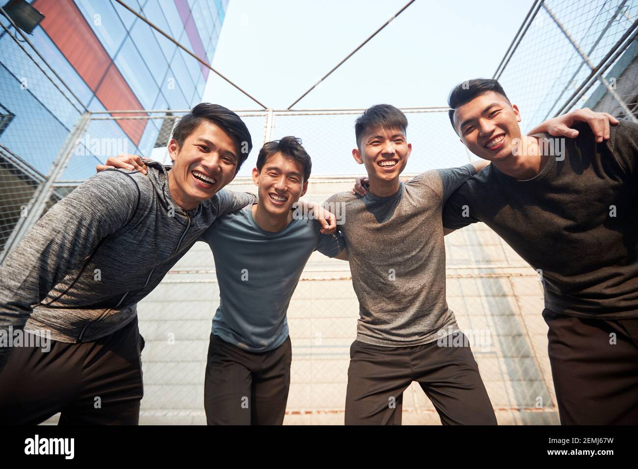 equipo de cuatro jóvenes atletas adultos asiáticos que se divierten al aire libre Foto de stock