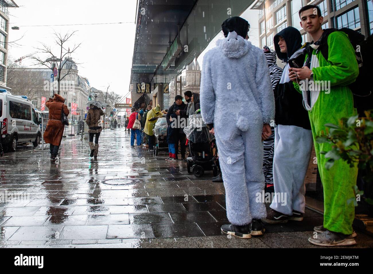Las personas con trajes se ven esperando mientras llueve y hace viento  durante el desfile. En Düsseldorf, el calendario de eventos de Carnaval  incluye no menos de 300 espectáculos de Carnaval, bailes,