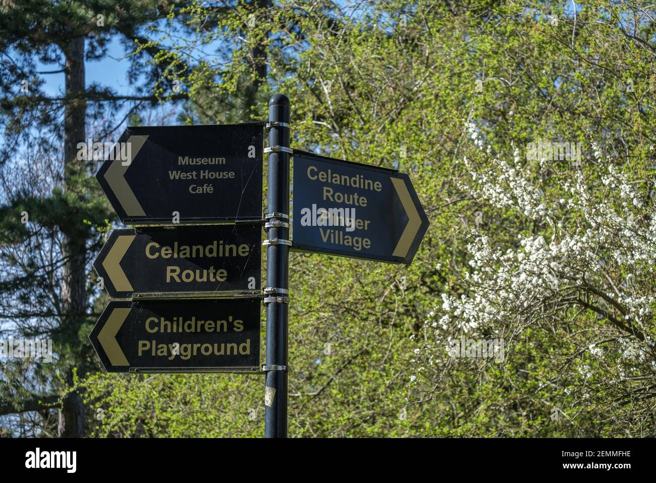 Poste con 4 señales en el Parque Memorial Pinner, señalando el parque infantil, la ruta Celandine, el museo, el pueblo Pinner y el café West House. Foto de stock
