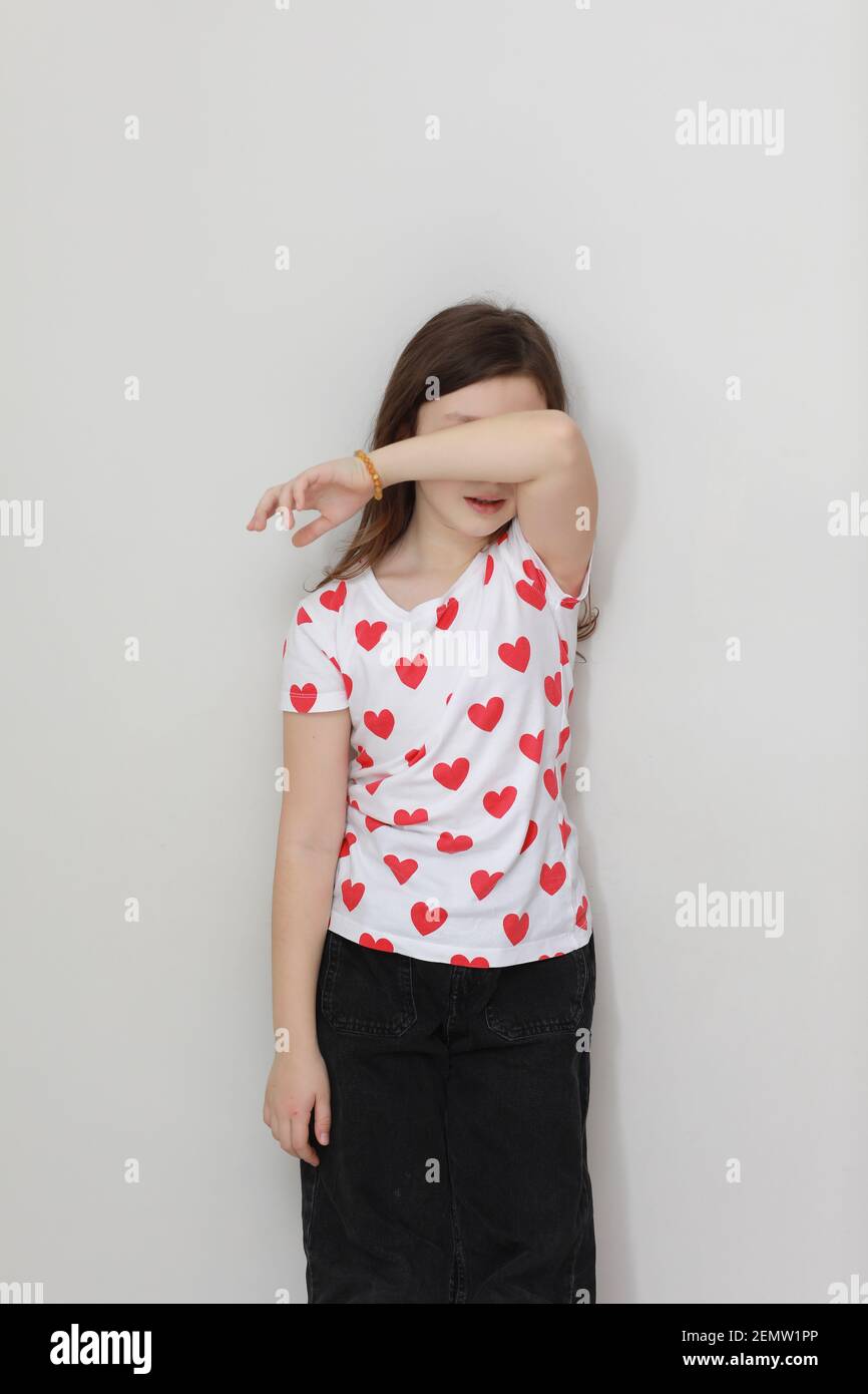 Lindo niño sonriente niña en camiseta blanca con corazones rojos, elegante pantalón  vaquero negro sobre fondo blanco. Día de san valentín Fotografía de stock -  Alamy