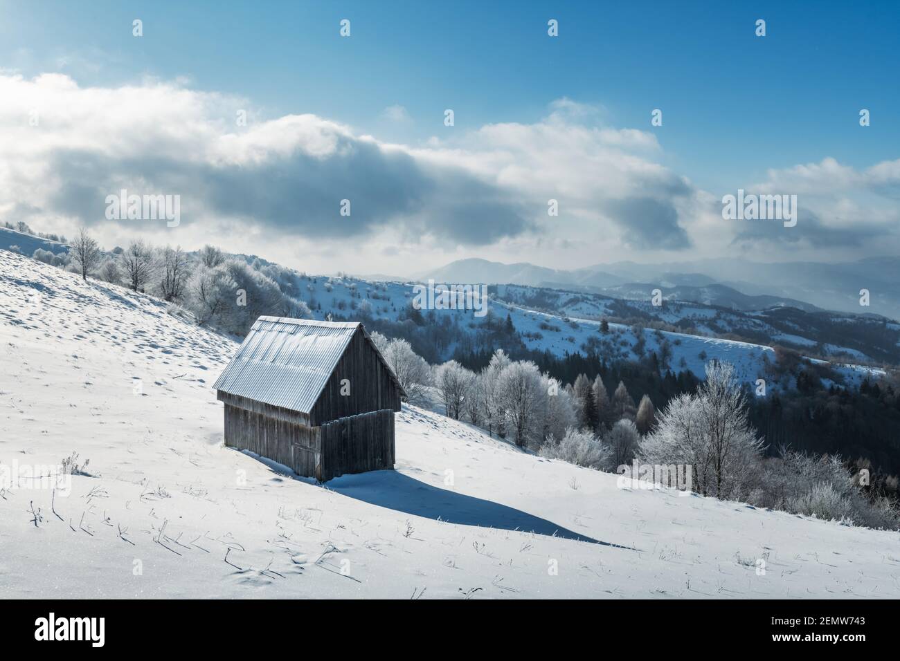 Fantástico paisaje invernal con cabaña de madera en bosque nevado. Casa acogedora en las montañas de los Cárpatos. Navidad concepto de vacaciones Foto de stock