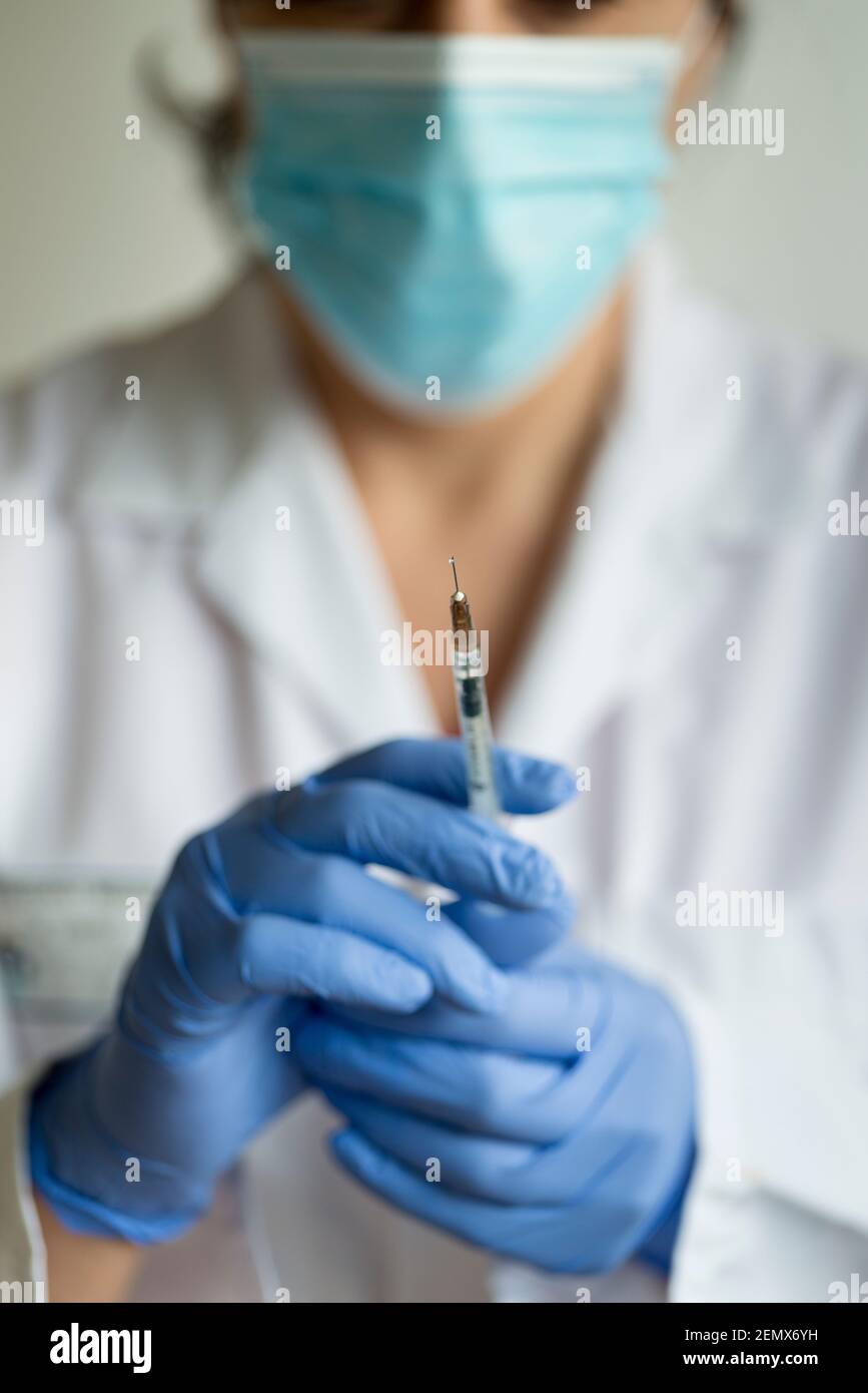 Enfoque selectivo-enfermera femenina, médico femenino sostiene la vacuna de covid-19, Programa de vacunación, Reino Unido Foto de stock