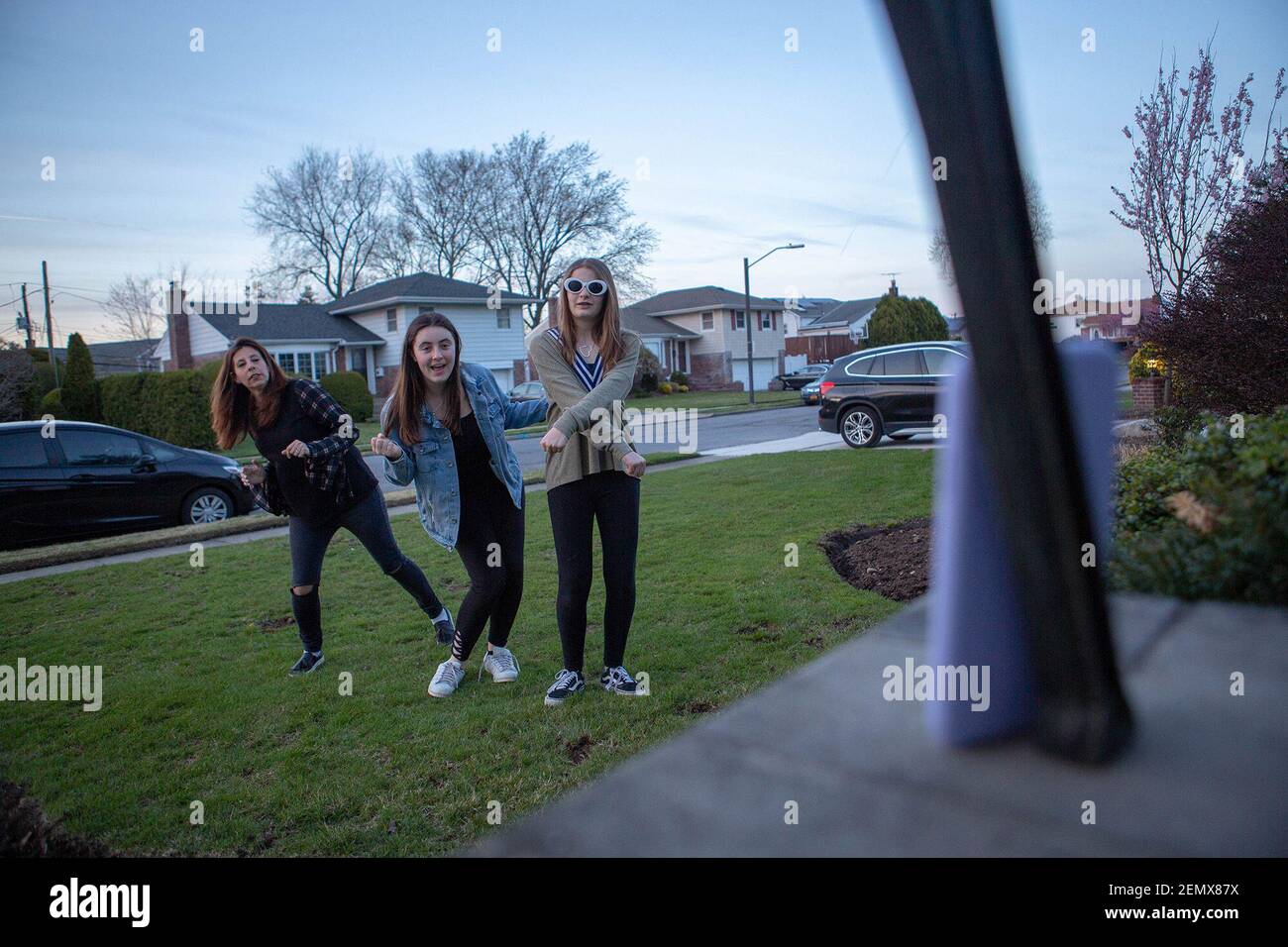 Jennifer Gutterson de Plainview, izquierda, e hijas, Alexa, centro, 16, y Ava, de 13 años, filmar un video para la aplicación Tiktok fuera de su casa el 17 de abril de 2019. (Foto de Shelby Knowles/Newsday/TNS/Sipa USA) Foto de stock