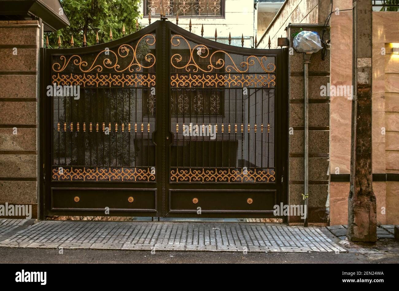 Puertas tradicionales de hierro de doble puerta de hierro forjado puertas  negras con decoración Rallando y realzado con patrones amarillos dorados a  lo largo de la calle Sepidan En Teh Fotografía de