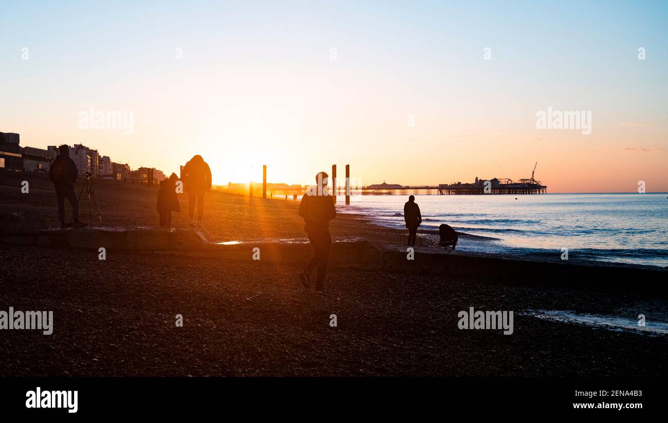 Brighton Reino Unido 26 de febrero de 2021 - los primeros pájaros captan el espectacular amanecer en Brighton esta mañana ya que el tiempo soleado se pronostica para los próximos días: Crédito Simon Dack / Alamy Live News Foto de stock