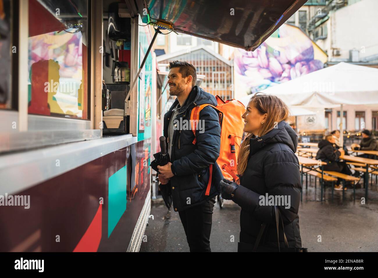 Feliz pareja de pie en el mostrador en el camión de alimentos Foto de stock