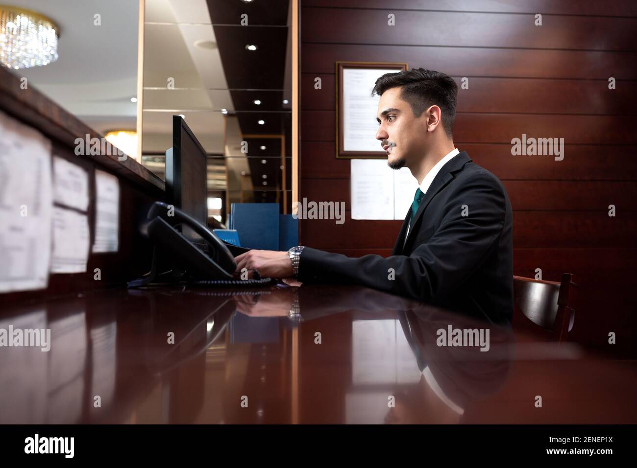 El Recepcionista Del Hotel Mantiene Sus Responsabilidades Y Dirige A Los Huespedes Y Sus Preguntas Fotografia De Stock Alamy
