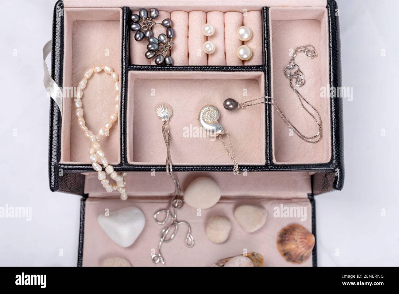 Día compañero Separar Colección de joyas de mar en caja de joyas sobre fondo de mármol claro con  conchas y guijarros. Collar colgante de perlas, pendientes de perlas y  cadenas de plata Fotografía de stock -