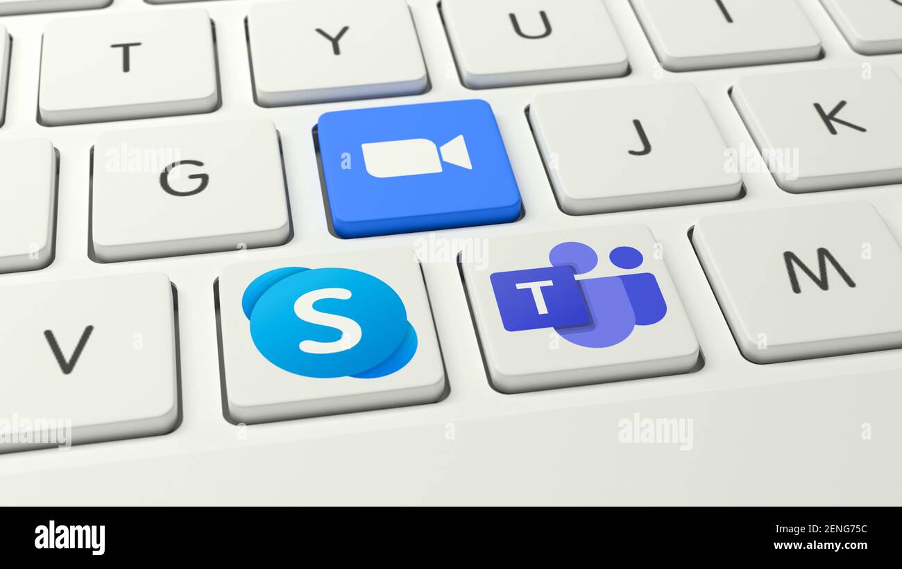 Logotipos de los sistemas de videoconferencia de la competencia Skype, Zoom y equipos de Microsoft (l.t. R.) como teclas en un teclado blanco. Foto de stock
