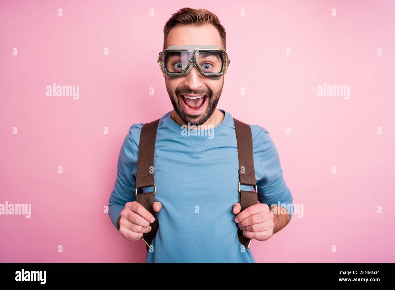 Foto de chico joven divertido y lindo llevar gafas de pulóver azules brazos  mochila listo para paracaidismo aislado color rosa fondo Fotografía de  stock - Alamy