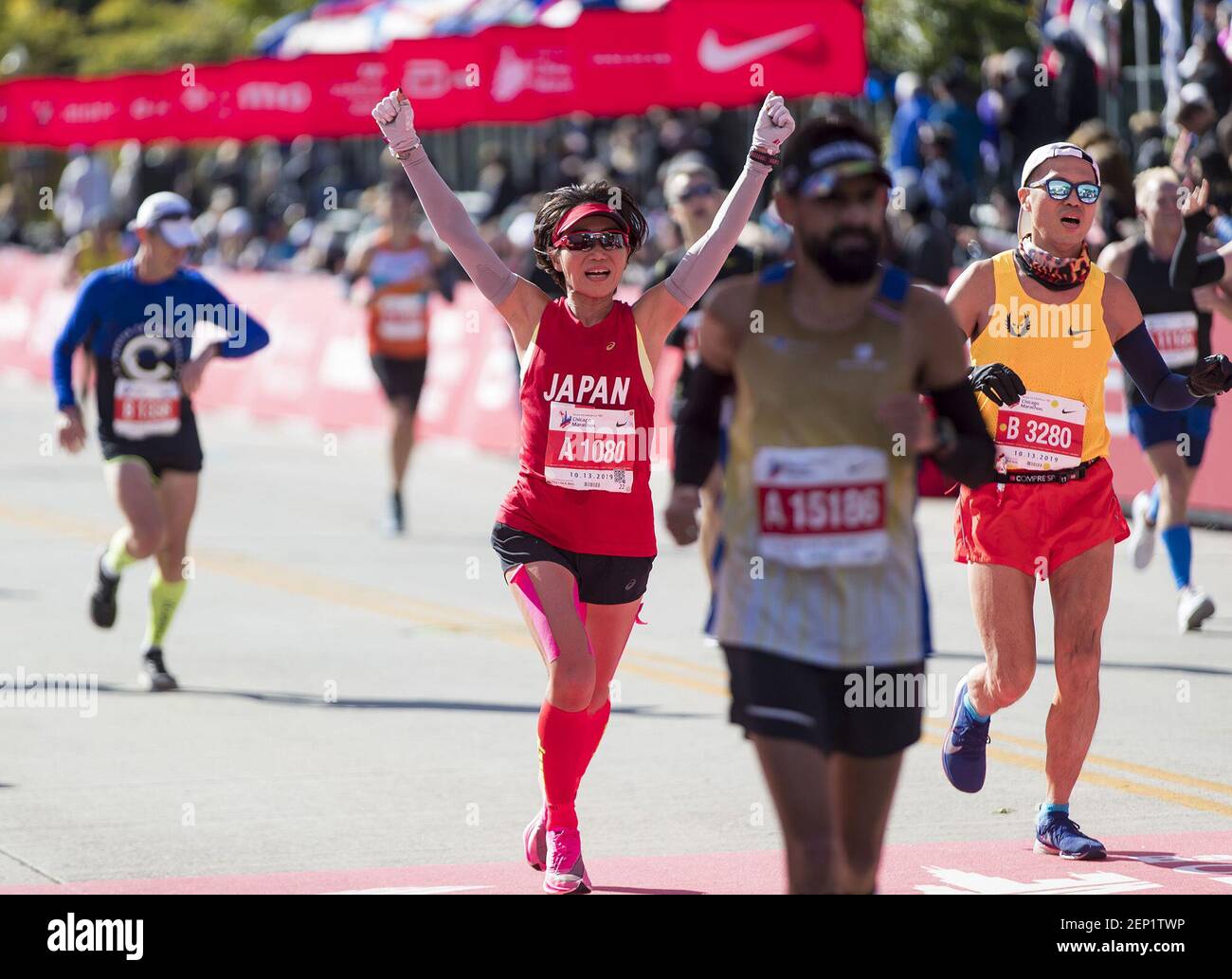 Los corredores reaccionan mientras cruzan la línea de meta el domingo, 13 de octubre de 2019 en el Maratón de Chicago. (Brian Cassella/Chicago Tribune/TNS) Foto de stock