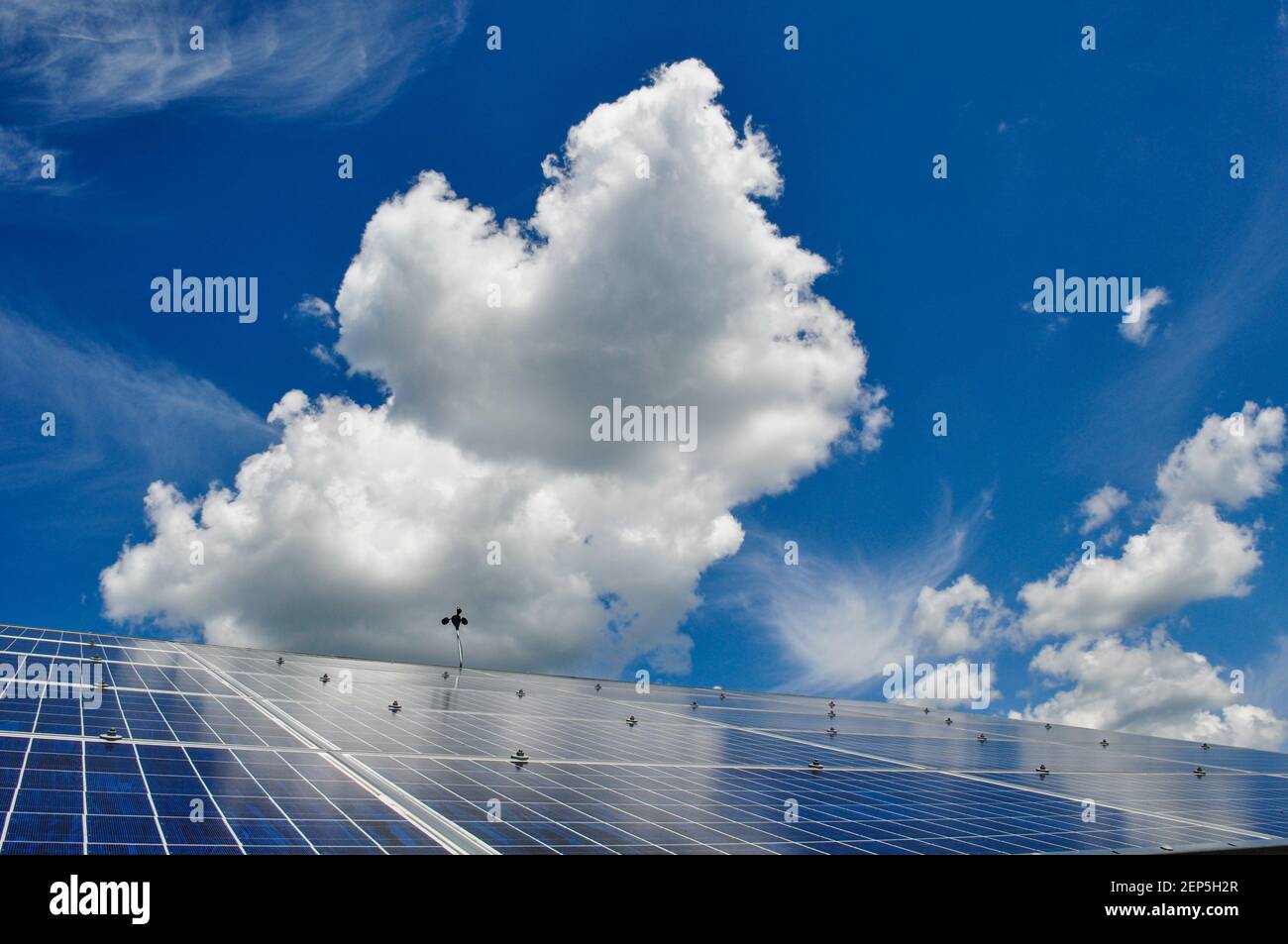 Vista espectacular de paneles solares fotovoltaicos y grandes nubes cumulosas y cielo azul, Craftsbury Outdoor Center, VT, EE.UU. Foto de stock