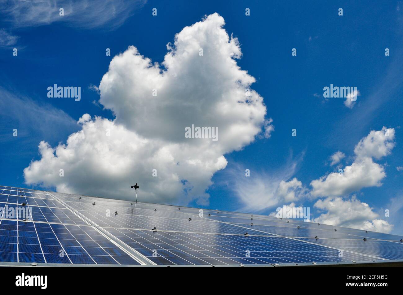 Vista espectacular de paneles solares fotovoltaicos y grandes nubes cumulosas y cielo azul, Craftsbury Outdoor Center, VT, EE.UU. Foto de stock