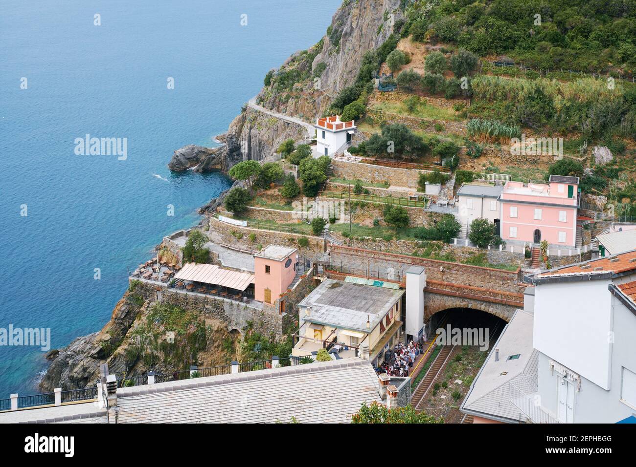Riomaggiore, Italia- 17 de septiembre de 2018:Vista superior de la famosa ciudad de Cinque Terre de Liguria, con estación de tren, mar y colina Foto de stock