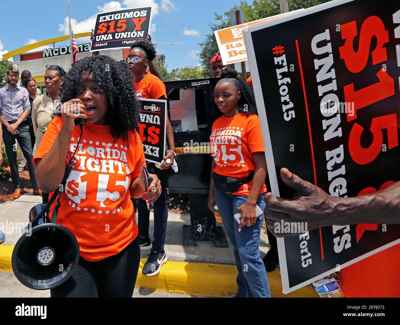 Noji Olaigbe, de izquierda, de la lucha por el movimiento de salario mínimo  de $15, habla durante una huelga de trabajadores de McDonald's en un  McDonald's en Fort Lauderdale, Fla. El jueves,