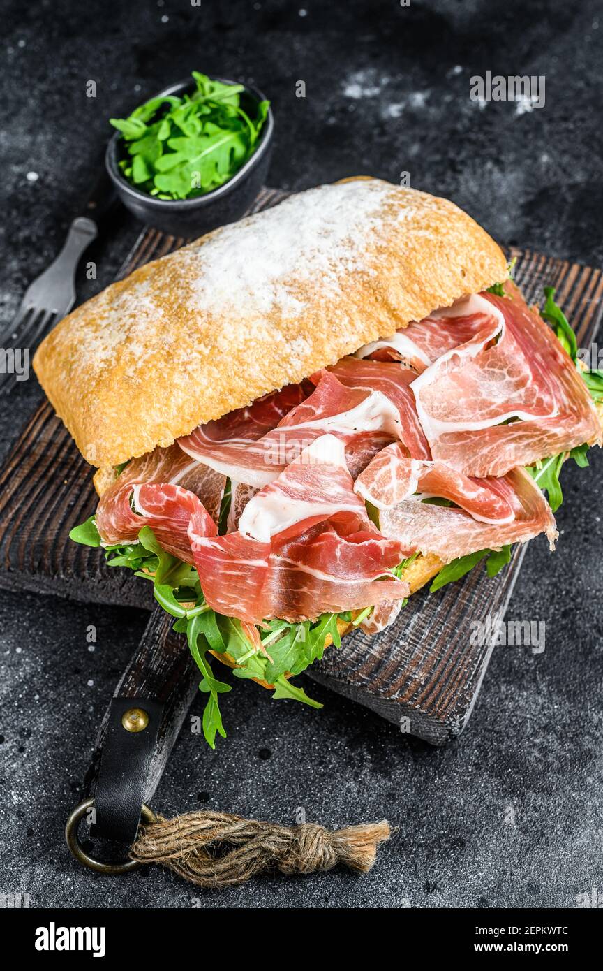 sándwich de jamón ibérico jamón sobre pan de ciabatta. Fondo negro