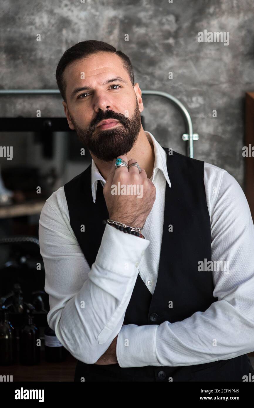 Adulto brutal ejecutivo en el desgaste formal y anillos tocar mientras la cámara en el salón de Fotografía de stock - Alamy