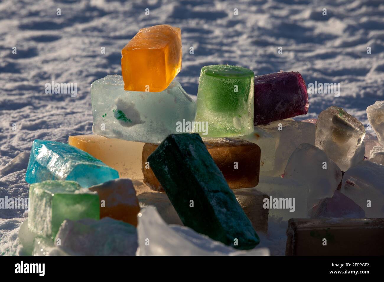 Ladrillos de hielo de colores o bloques retroiluminados por el sol de la noche Foto de stock