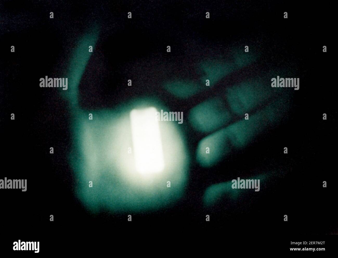 Fosforescencia, 1986. Un pedazo de plástico fosforescente en la oscuridad, unos segundos después de haber sido excitado por una pistola de flash. Foto de stock