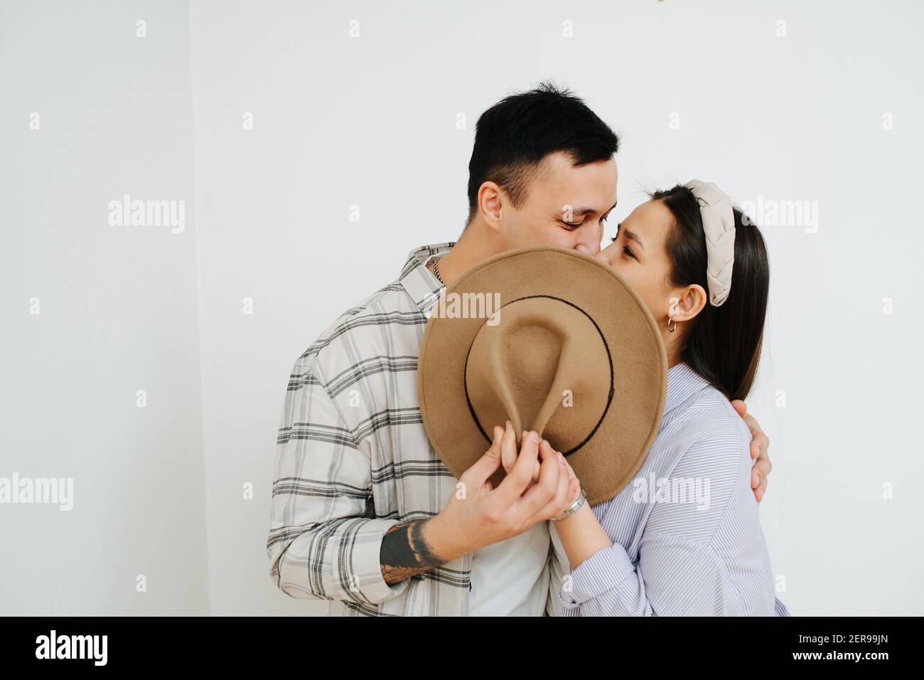 hombre y mujer besando escondiéndose detrás de un sombrero Fotografía de  stock - Alamy