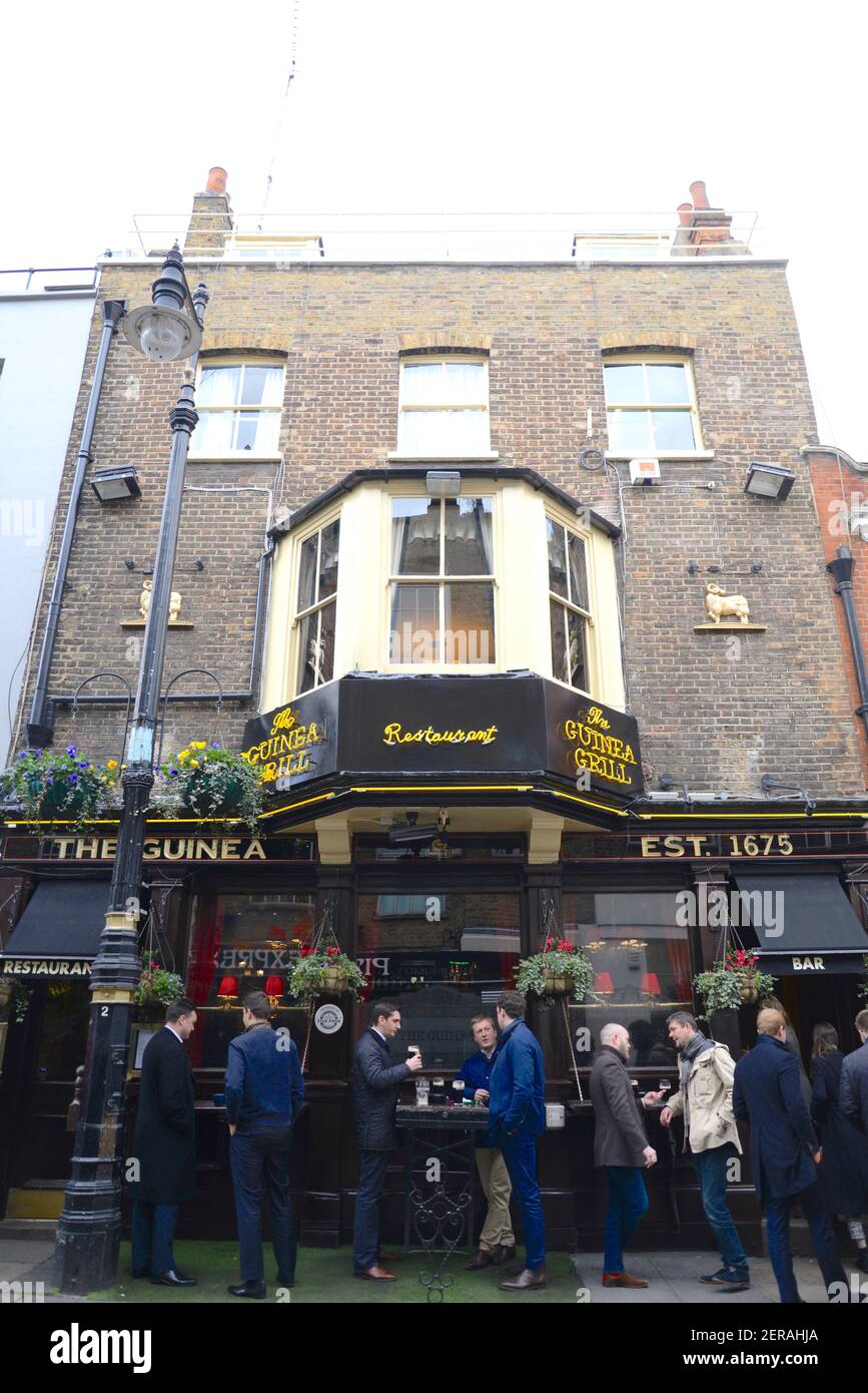 Gente bebiendo fuera del pub de Guinea en Mayfair, Londres Foto de stock