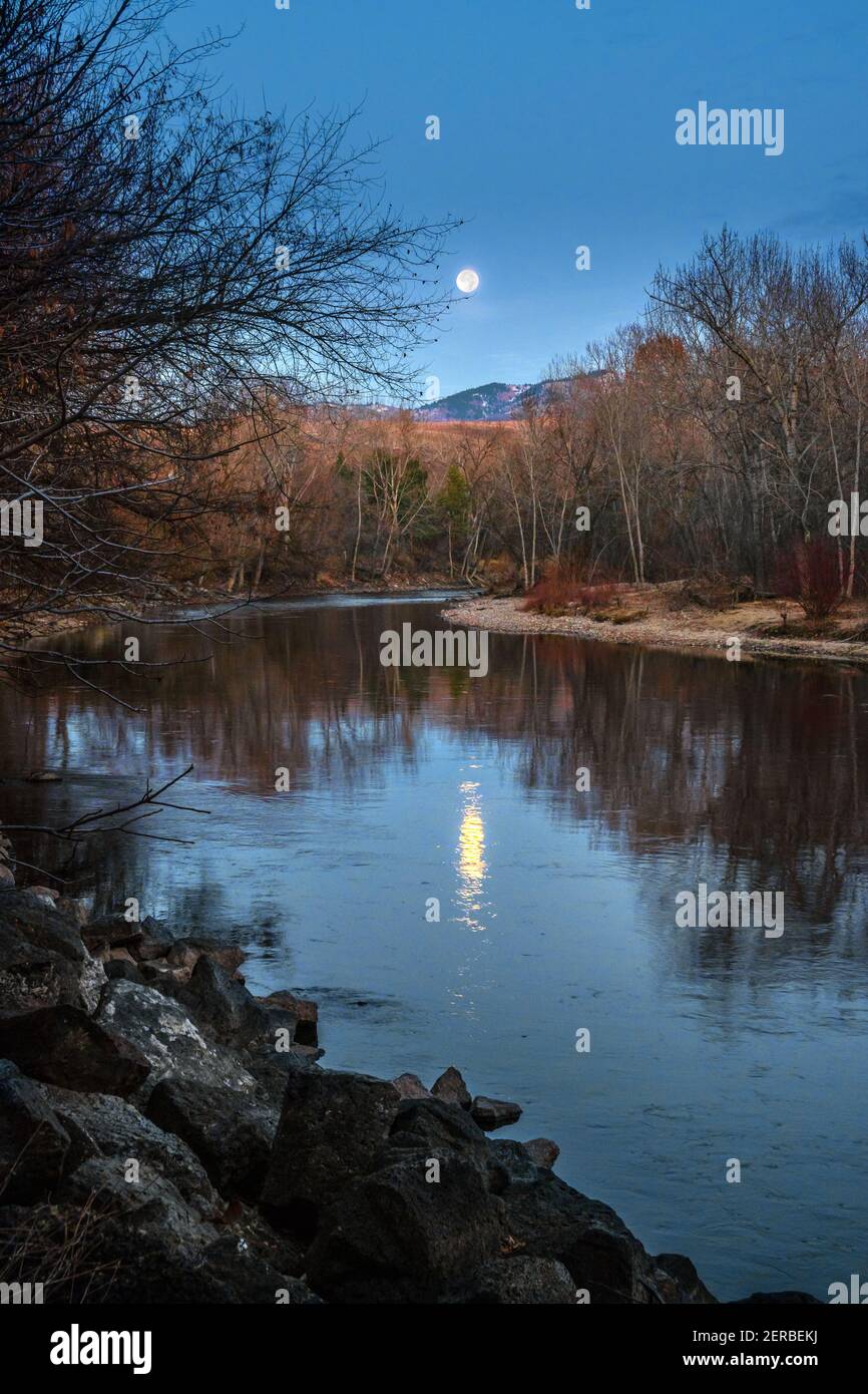 La luna casi llena se eleva sobre el río Boise en una noche de noviembre. Foto de stock