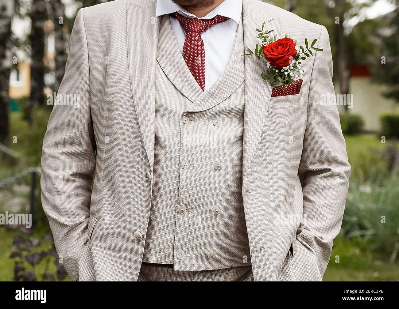 El traje beige claro del novio con un boutonniere y un primer plano de  corbata roja Fotografía de stock - Alamy