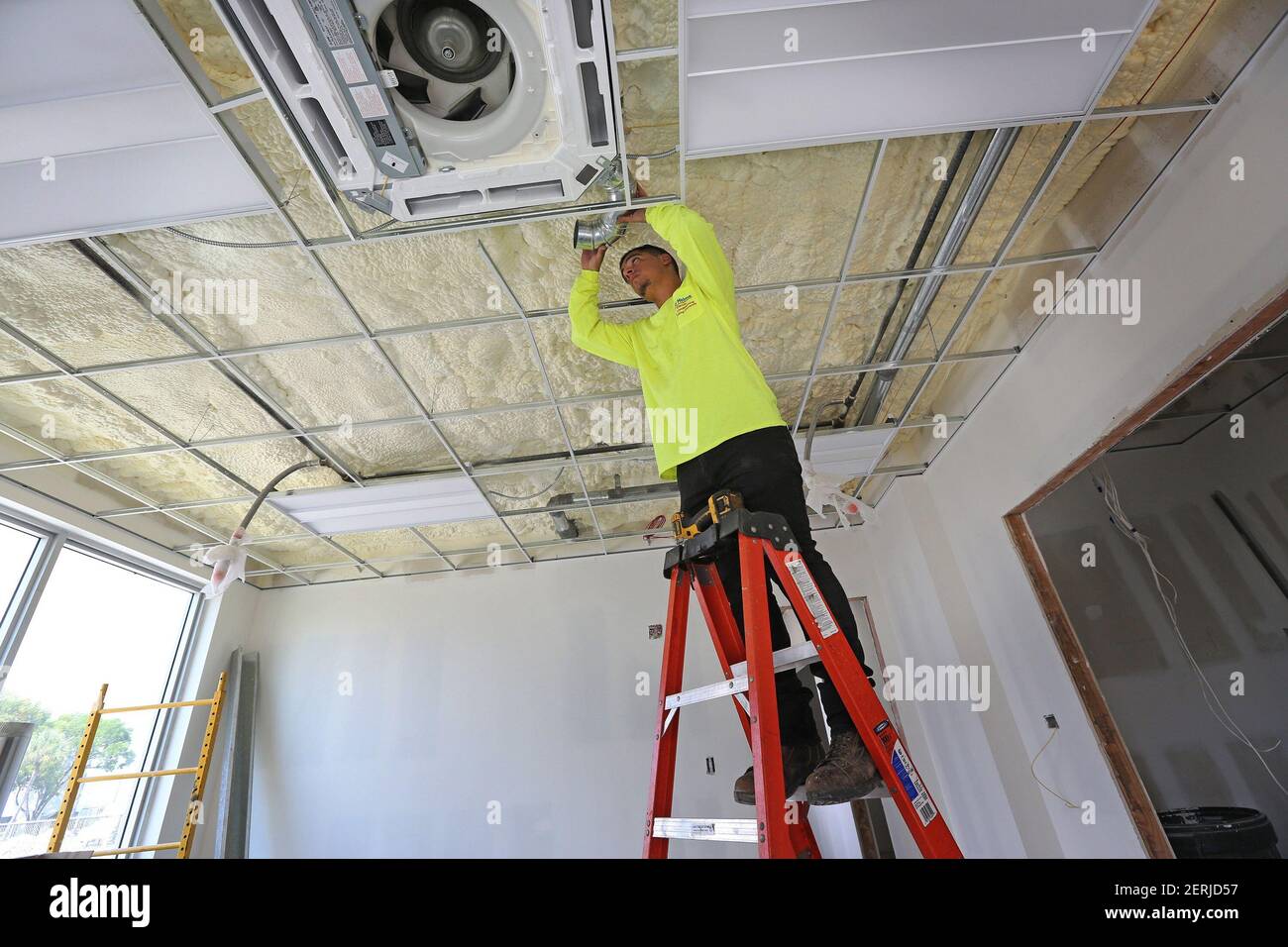 Eduardo Pupo, 24, de Hollywood, Fla., trabaja en la instalación de  ventilación para una unidad de aire acondicionado en uno de los nuevos  edificios del centro de entrenamiento de ARPEC en Sweetwater,