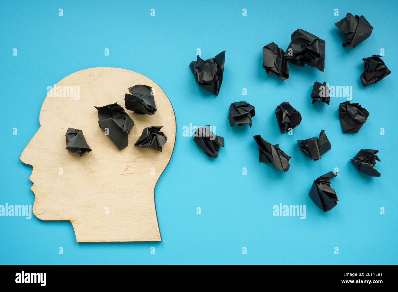 Forma de la cabeza con bolas de papel negro como símbolo de depresión y pensamientos negativos. Foto de stock