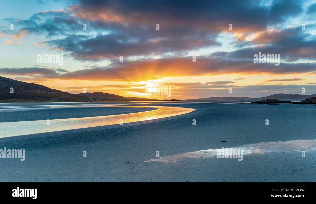 Puesta de sol sobre la enorme playa de arena en Luskentire en el Isla de harris en Escocia Foto de stock