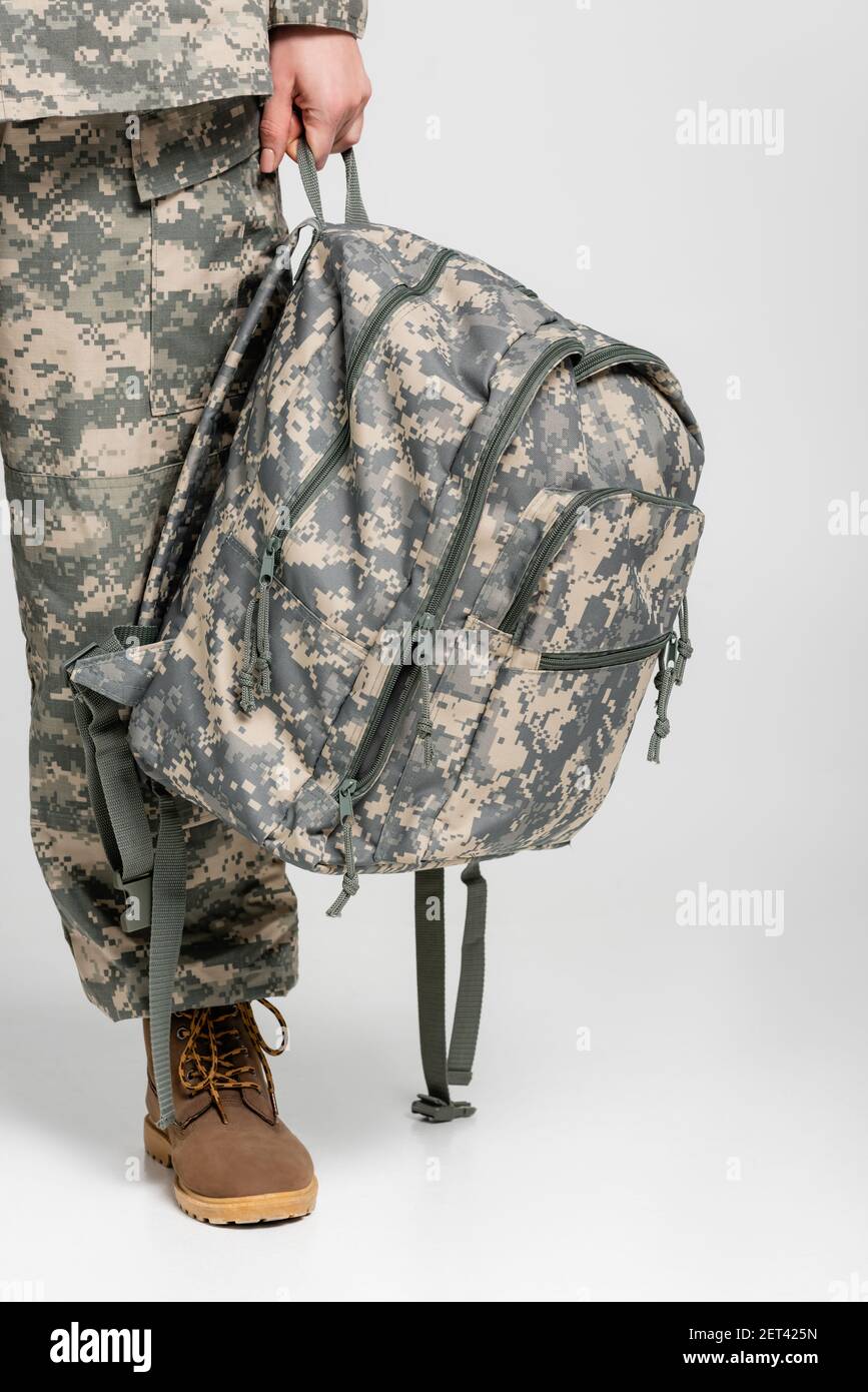 escaldadura Interpersonal Esperar Vista recortada de la mujer con ropa militar sosteniendo la mochila fondo  gris Fotografía de stock - Alamy