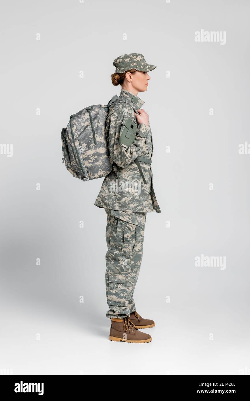 Vista lateral de la mujer en uniforme militar con la mochila fondo gris  Fotografía de stock - Alamy