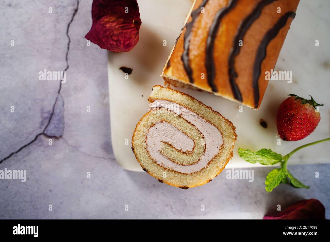 Rollo suizo de fresa o Roulade con relleno de crema y llovizna de chocolate, enfoque selectivo Foto de stock