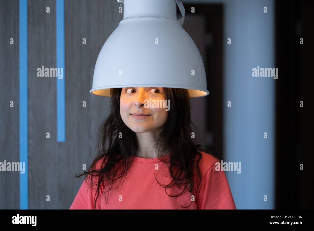 Chica que se burla de usar una lámpara de pie como secador de pelo  Fotografía de stock - Alamy