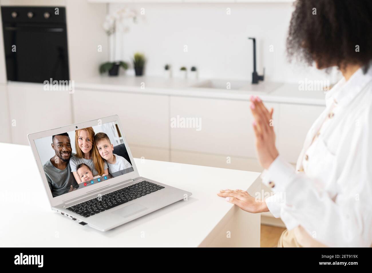 Concéntrate en la pantalla con la feliz familia multirracial, haciendo videollamadas con una hija mayor o hermana, charlando comunicándose en línea usando la aplicación de computadora, permaneciendo en casa en aislamiento Foto de stock