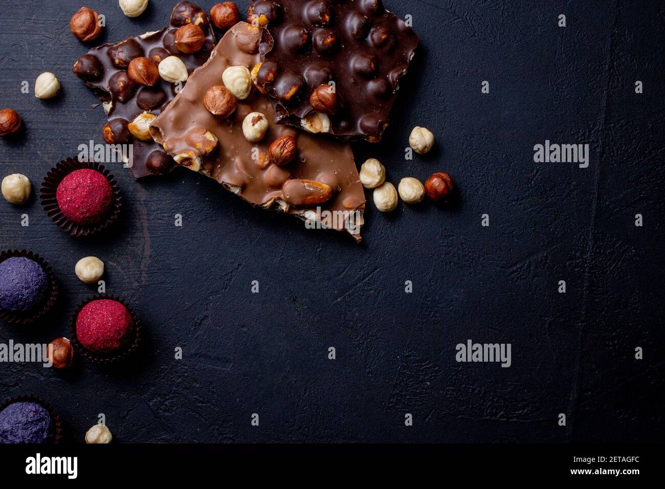 Trufa de chocolate con trozos de chocolate y polvo de cacao volador sobre un fondo oscuro Foto de stock