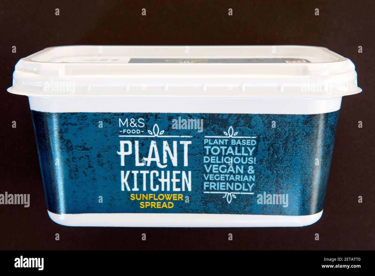 Tina de M&S planta de alimentos Cocina Vegan girasol extender lácteos margarina libre aislada en la parte trasera negra Foto de stock