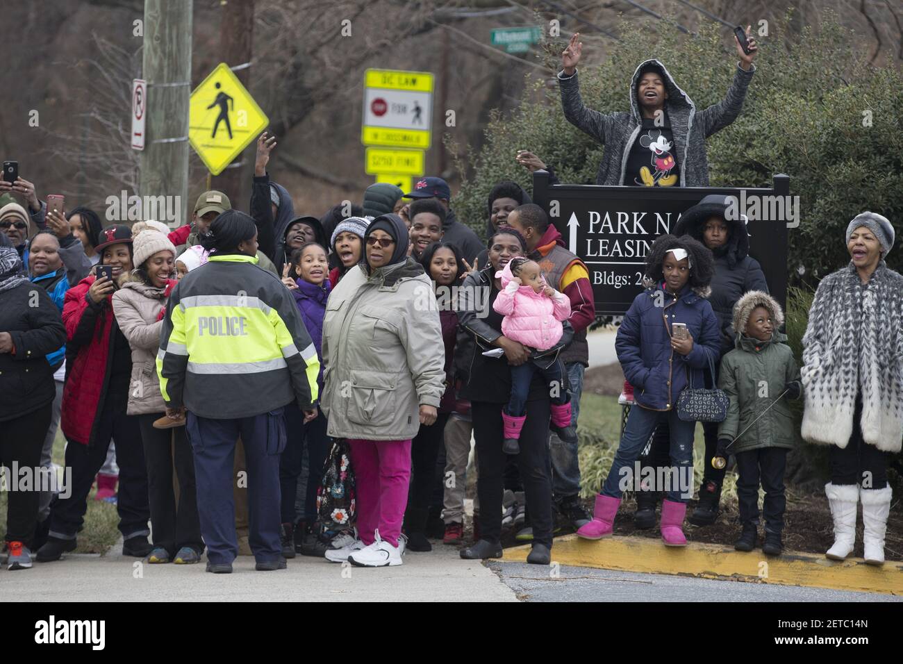 La gente local anima fuera de un evento de servicio al que asistió el