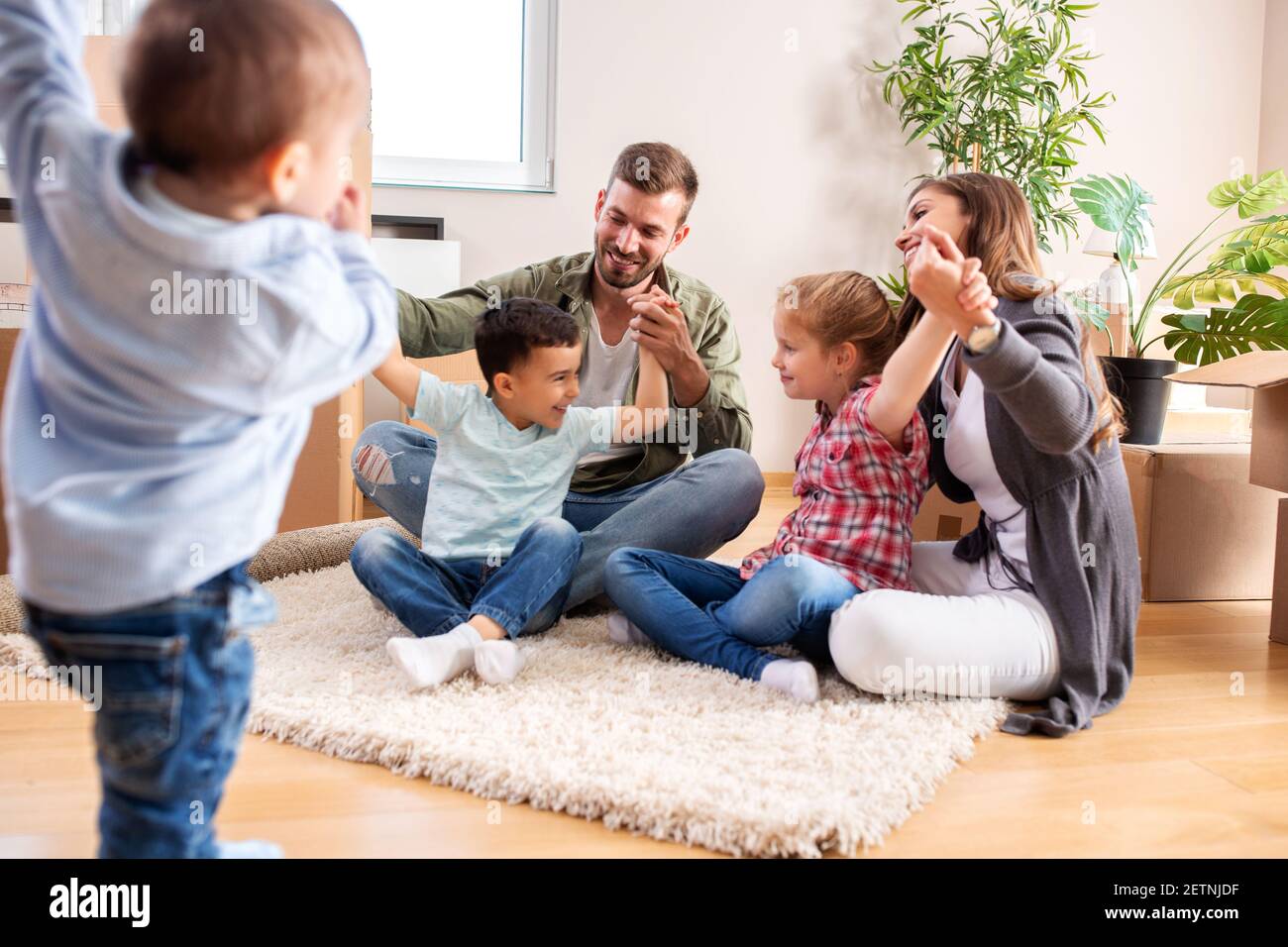 Recién se mudó en familia relajándose en casa nueva mientras hacía un descanso Foto de stock