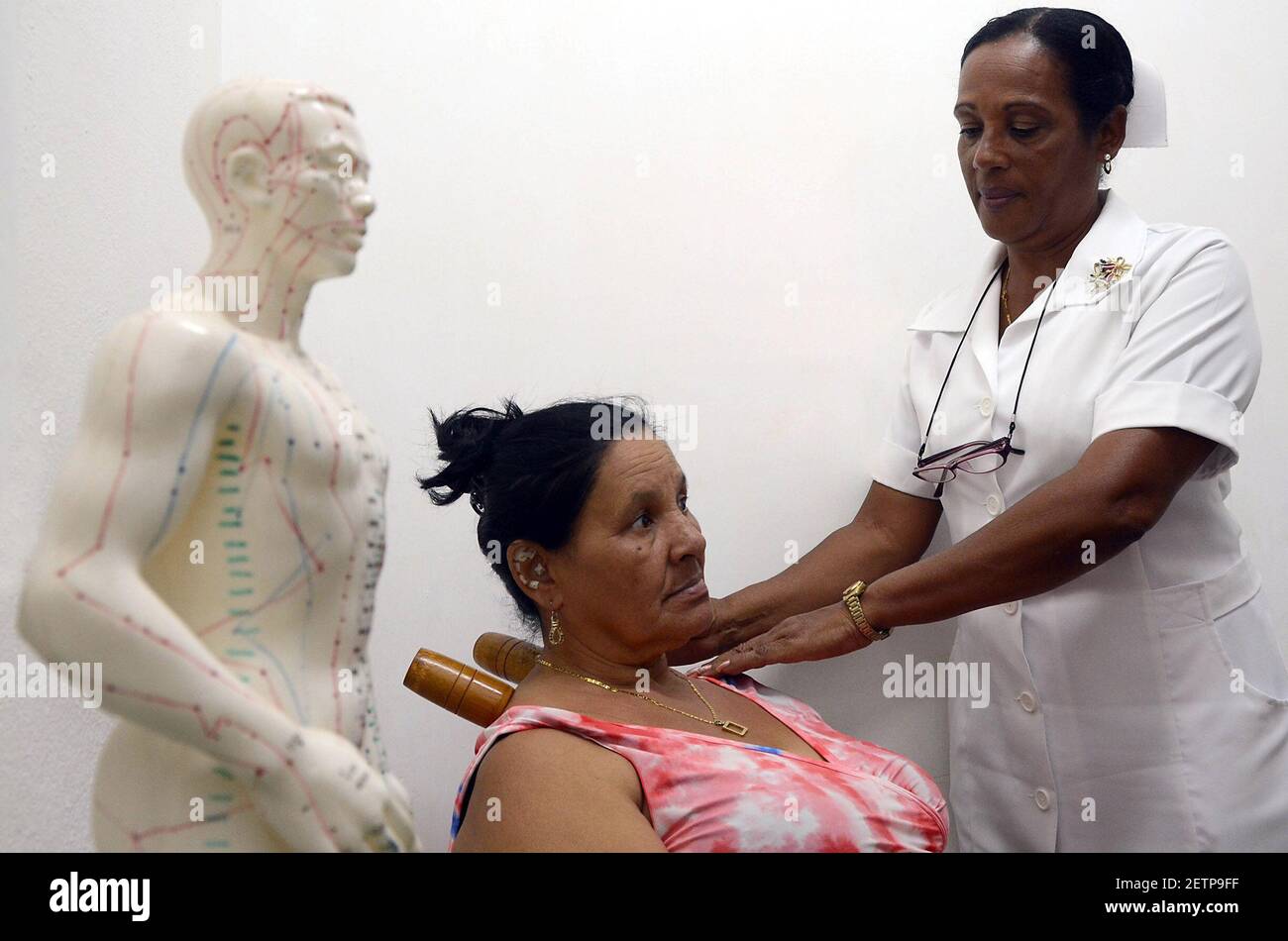 (170423) -- LA HABANA, 23 de abril de 2017 (Xinhua) -- la imagen tomada el 2 de marzo de 2017 muestra a una enfermera que aplica un tratamiento de medicina tradicional y natural a un paciente en el centro de atención primaria Camilo Cienfuegos en la Habana, Cuba. En los últimos 20 años, la medicina tradicional China (MCT) ha ido ganando terreno en Cuba como una nueva forma de aliviar las dolencias y tratar los dolores y las enfermedades crónicas. Los cubanos se han beneficiado desde la década de 1990 de la MCT, cuyas raíces antiguas se han profundizado en la conciencia de la isla sin necesidad de realizar campañas publicitarias. (Xinhua/Joaquín Hernández) (ma) (fnc) (Foto de Xinh Foto de stock