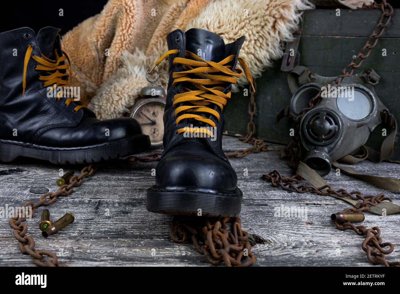 Botas de cuero con cadenas oxidadas y conchas de bala con militares máscara  de gas y pelaje de pelo en el fondo descansando sobre madera tabla  Fotografía de stock - Alamy