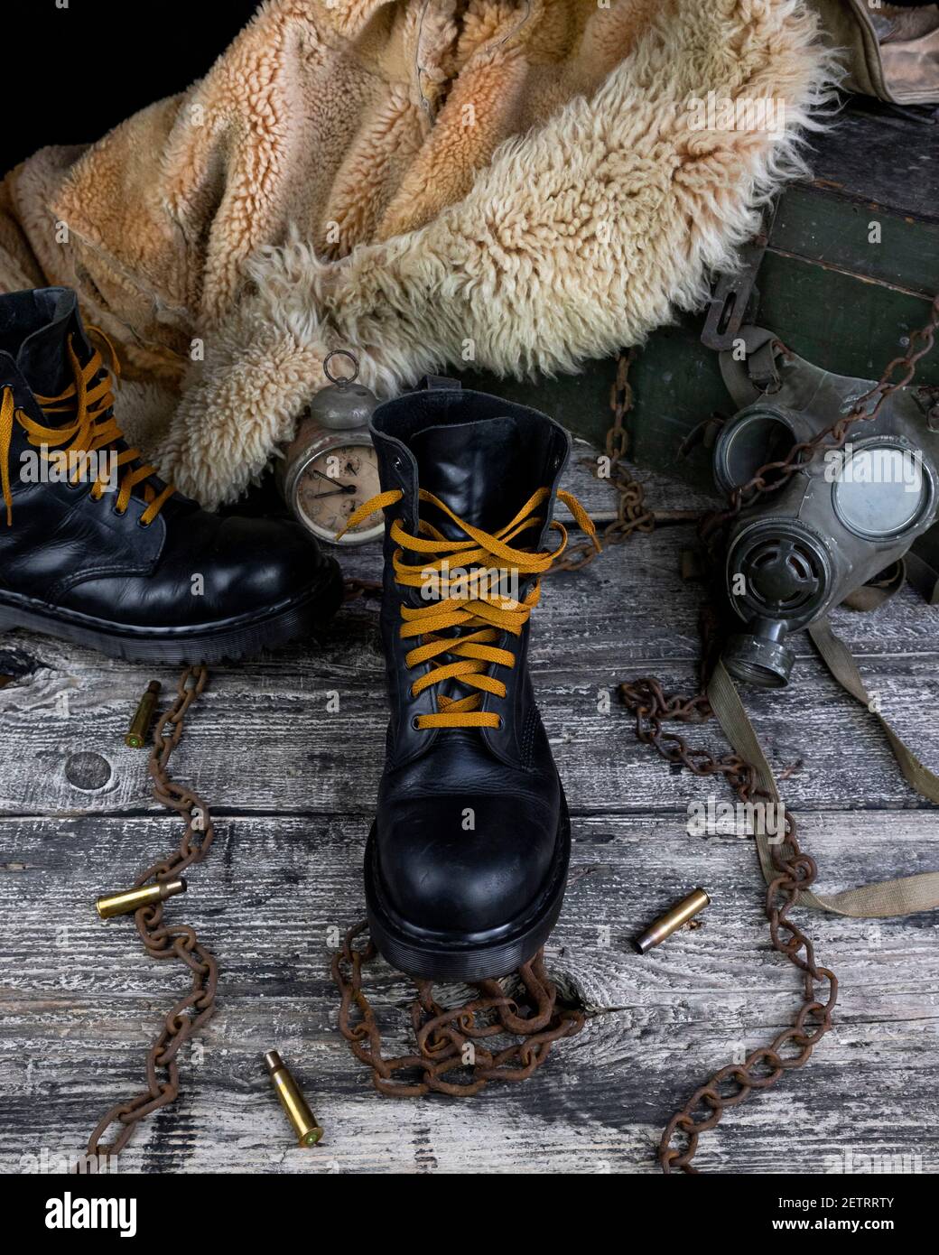 Botas de cuero con cadenas oxidadas y conchas de bala con militares máscara  de gas y pelaje de pelo en el fondo descansando sobre madera tabla  Fotografía de stock - Alamy